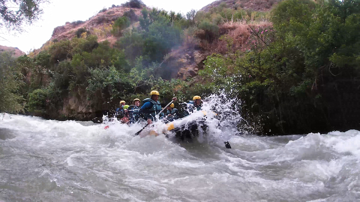 A group of people rowing on a raft